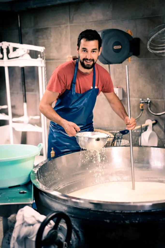 Casaro alla Malga Contrin mentre lavora alla produzione artigianale del formaggio