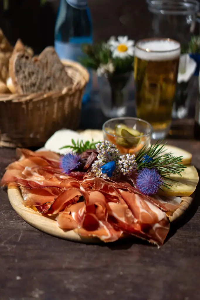 Tagliere di salumi e formaggi tipici alla Malga Contrin con pane fatto in casa e birra fresca